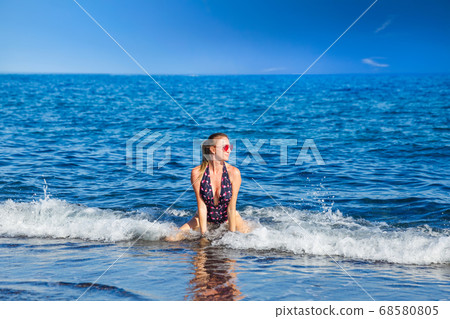 Young woman in the sea waves Young woman in the sea waves 68580805