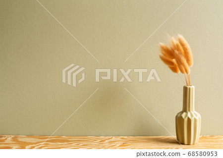 Vase of pink hares tail grass (Lagurus ovatus) dry flowers on wooden table with khaki background 68580953