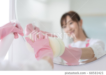 清洗鏡子在浴室消毒的年輕女子 清洗鏡子在浴室消毒的年輕女子 68581421