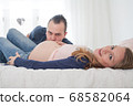 pregnant couple on bed 68582064