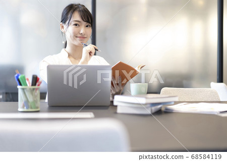 A woman checking the schedule book at the office seat 68584119