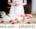 woman makes dumplings at home on kitchen table, close up 68584541