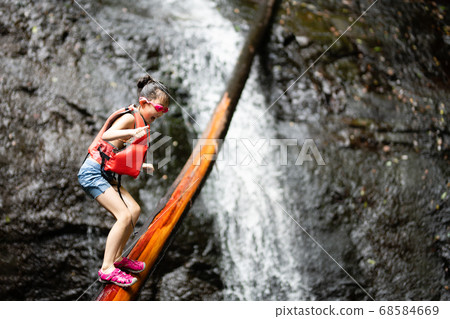 Child playing in a waterfall Child playing in a waterfall 68584669