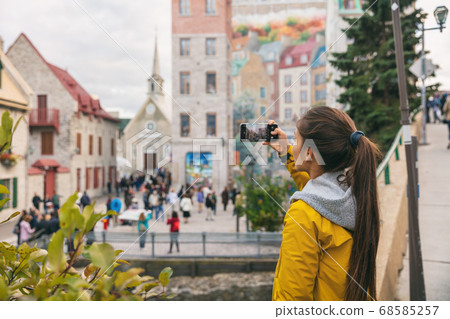 Quebec city old town woman tourist taking picture with phone of famous wall art mural in Place Royale, Autumn Canada travel Quebec city old town woman tourist taking picture with phone of famous wall art mural in Place Royale, Autumn Canada travel 68585257