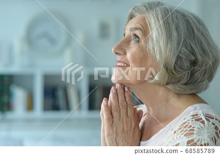 Portrait of a beautiful senior woman praying 68585789