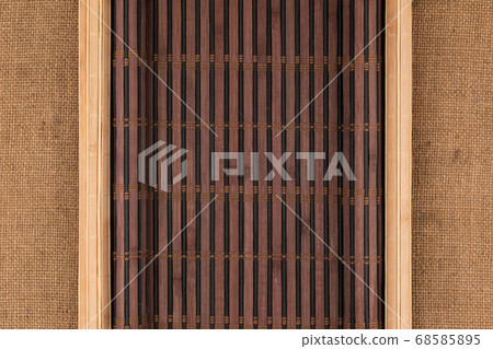 Two bamboo mat with curled edges lie on sacking. Two bamboo mat with curled edges lie on sacking. 68585895