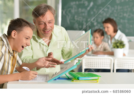 Father helping his son doing homework in classroom 68586060