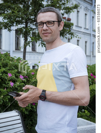 white man with a gadget on the street in the city white man with a gadget on the street in the city 68586073
