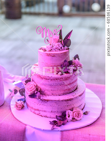 Beautiful wedding cake with cream With text MR MRS on top pink flowers roses 68586139