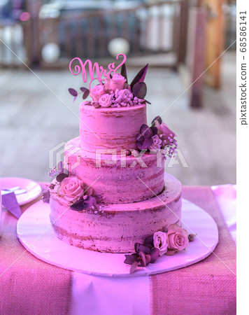 Beautiful wedding cake with cream With text MR MRS on top pink flowers roses Beautiful wedding cake with cream With text MR MRS on top pink flowers roses 68586141