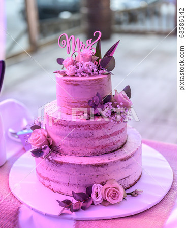 Beautiful wedding cake with cream With text MR MRS on top pink flowers roses Beautiful wedding cake with cream With text MR MRS on top pink flowers roses 68586142