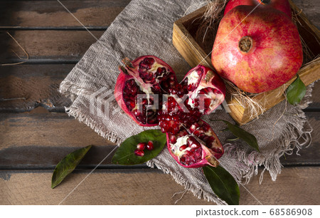 ripe red juicy pomegranate on a napkin, a box with ripe red juicy pomegranate on a napkin, a box with 68586908