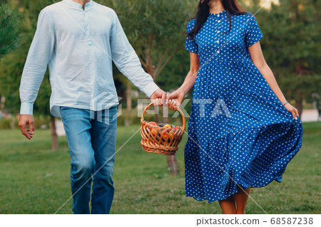 Happy Couple with Fruits in Picnic Basket Walking in the Park. Happy Couple with Fruits in Picnic Basket Walking in the Park. 68587238