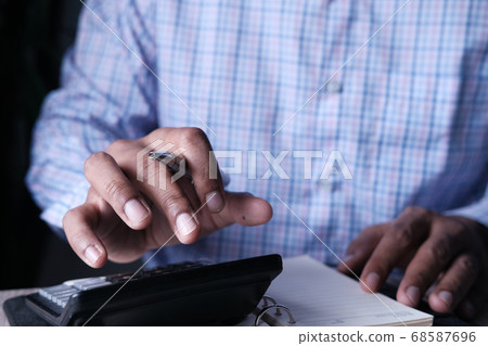 Close up of man hand using calculator Close up of man hand using calculator 68587696