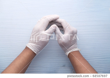Doctor hand with glove on wooden background. 68587697