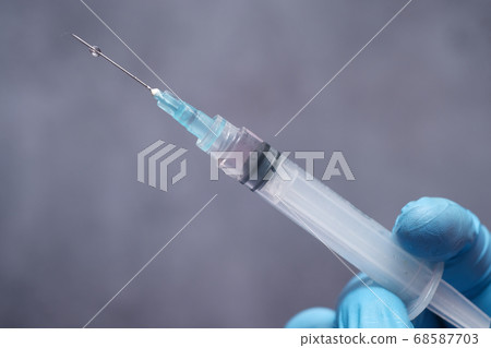doctor hand in medical gloves holding syringe. doctor hand in medical gloves holding syringe. 68587703
