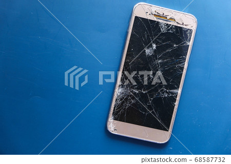 Top view of broken smart phone on color background Top view of broken smart phone on color background 68587732
