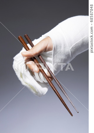 Injured hand holding chopsticks Injured hand holding chopsticks 68587848