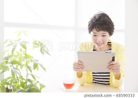 一個女人看著一台平板電腦 68590333