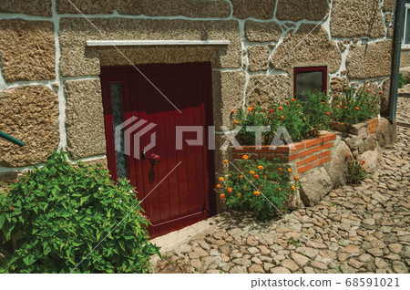Facade of stone house with a wooden door 68591021
