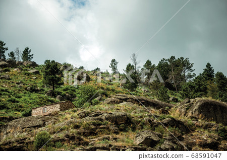 Rustic stone house on a hilly landscape Rustic stone house on a hilly landscape 68591047