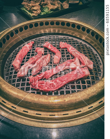 Japanese BBQ restaurant barbecue grill top view of table grilling yakiniku of raw steak meat premium cuts. Japan culture dining experience cooking 68591155