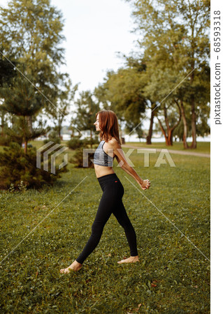 Beautiful girl doing a warm-up before yoga in the park. Beautiful girl doing a warm-up before yoga in the park. 68593318