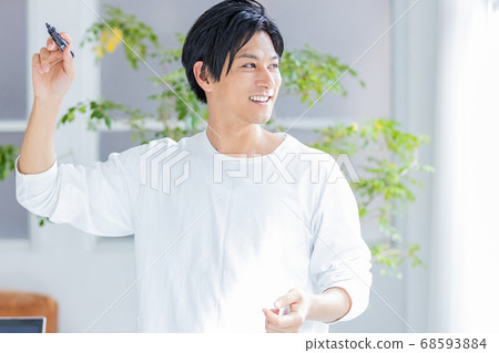 A young man talking in public with a whiteboard marker A young man talking in public with a whiteboard marker 68593884