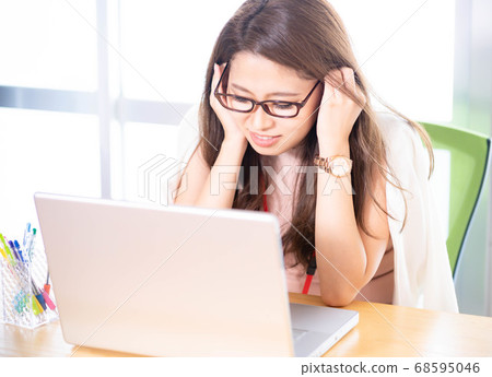 Young woman with glasses wearing elbows at the desk Young woman with glasses wearing elbows at the desk 68595046