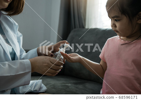 Female pediatrician is holding a bottle of alcohol 68596171