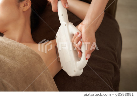 Japanese woman getting hair removal on her side at the beauty salon 68598091