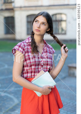 Girl student in red skirt and plaid shirt 68599123