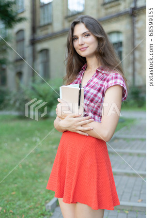 Girl student in red skirt and plaid shirt 68599155