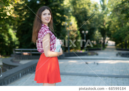 Girl student in red skirt and plaid shirt 68599184