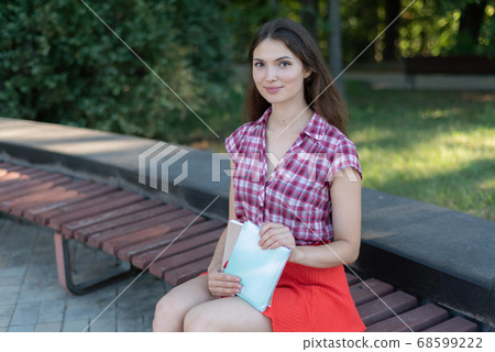 Young girl student on a bench in the daytime 68599222