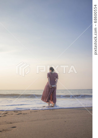 One-piece woman standing on the coast in the morning 68600554