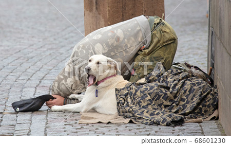 Beggar with dog begging for alms on the street in Beggar with dog begging for alms on the street in 68601230