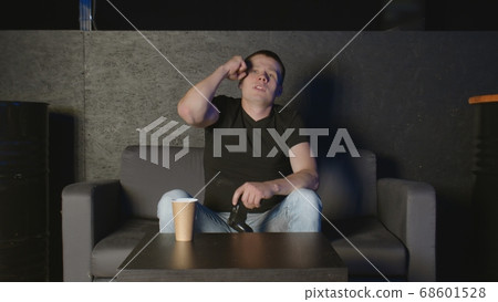 Young man playing console game in front of camera, beating his opponent online. White man on sofa. Young man playing console game in front of camera, beating his opponent online. White man on sofa. 68601528