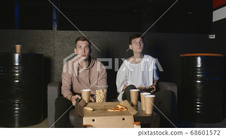 Two gamers in front of the screen are playing together in the online battle 68601572