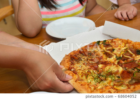 Distributing a home-delivered pizza to children ・Hands of mother and child 68604052
