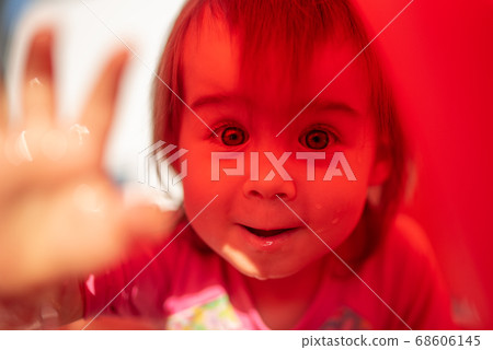Baby girl with big brown eyes outdoors portrait. Little girl 1-2 year old. Orange color, child in inflatable orange pool in sunny summer. Baby girl with big brown eyes outdoors portrait. Little girl 1-2 year old. Orange color, child in inflatable orange pool in sunny summer. 68606145