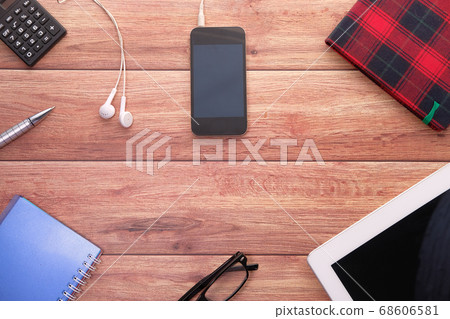 Top view of smart phone, digital tablet and notepad on table 68606581