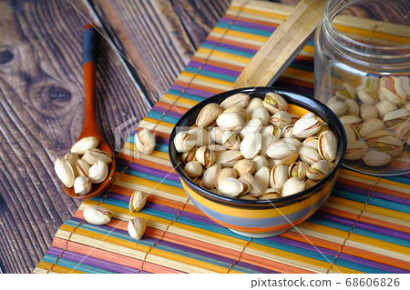 salted pistachios nut in a jar on table cloth. salted pistachios nut in a jar on table cloth. 68606826