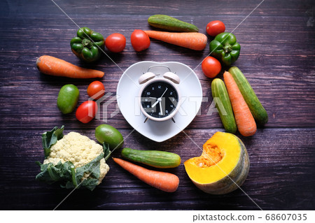 Food clock and fresh vegetable on table. 68607035