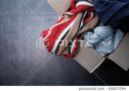 Donation box with donation clothes on a wooden table . 68607094