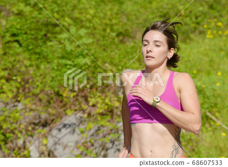 Beautiful athletic woman running in countryside 68607533