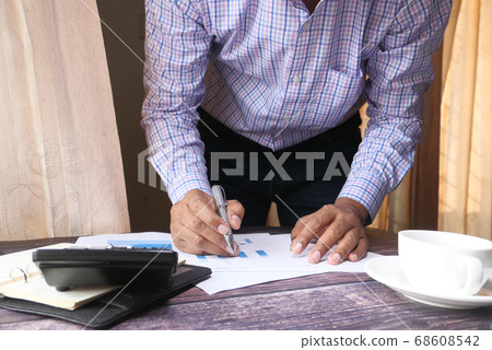 The concept of working from home. businessman analyzing financial data on desk, The concept of working from home. businessman analyzing financial data on desk, 68608542
