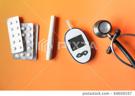 top view of diabetic measurement tools and pills on orange background  68608587