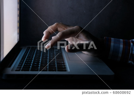 hacker hand stealing data from laptop at night  68608692