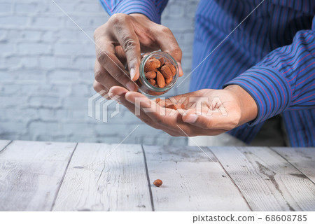 person hand holding a jar of almond with copy space  68608785